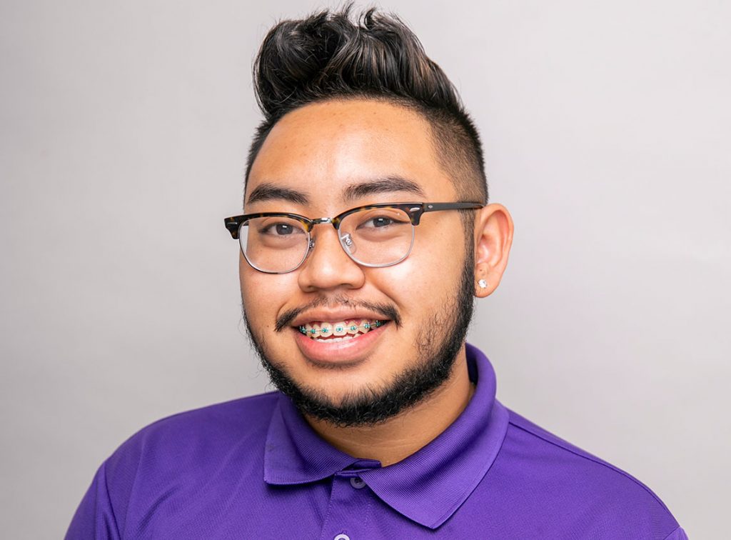 Headshot of young man wearing glasses smiling named John Nguyen.