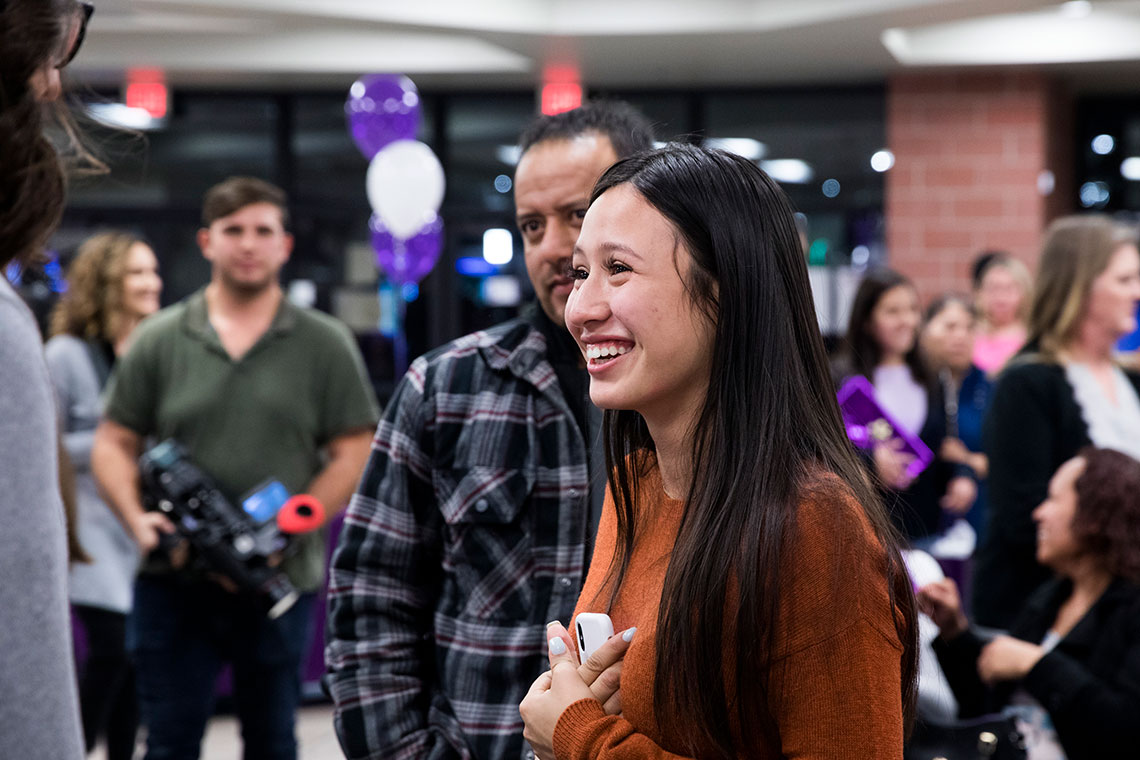 Student smiling in crowd at SIS ceremony
