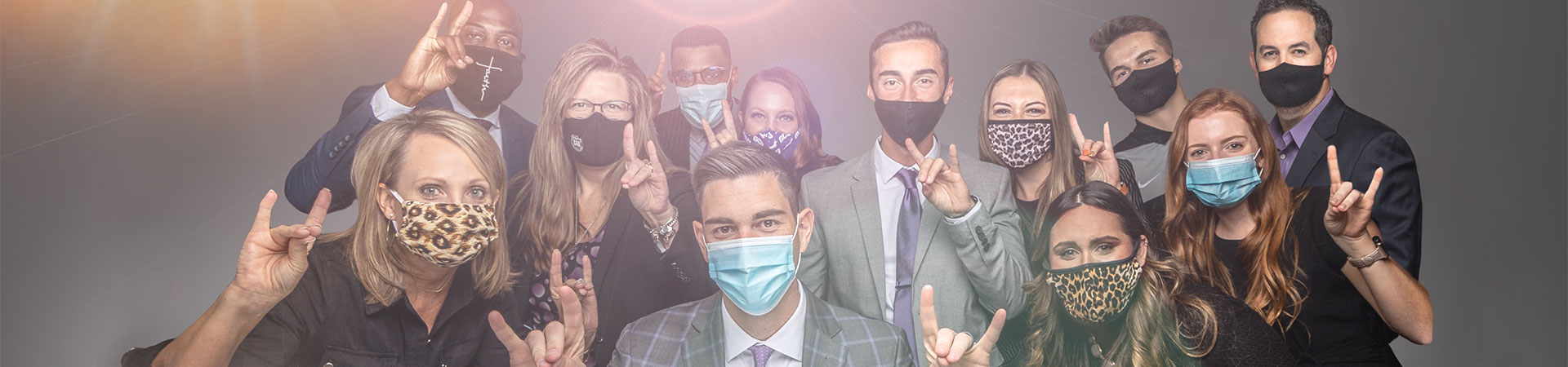 GCU Advancement team wearing masks and giving Lopes Up sign