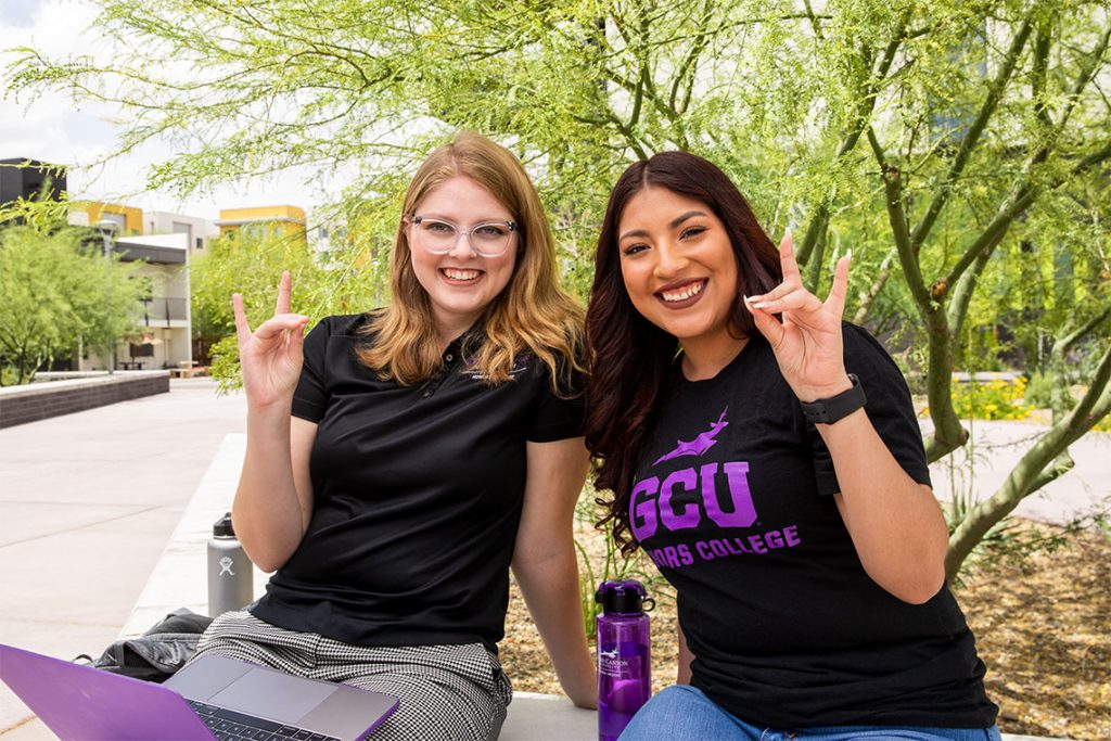 Two female honors college students smiling at the camera