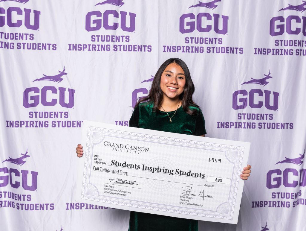 Student holding up SIS scholarship check